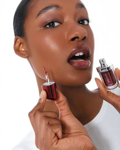 Mulher segurando sérum facial AMUSE com conta-gotas