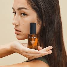 Mulher apoiando frasco de sérum Longtake na mão